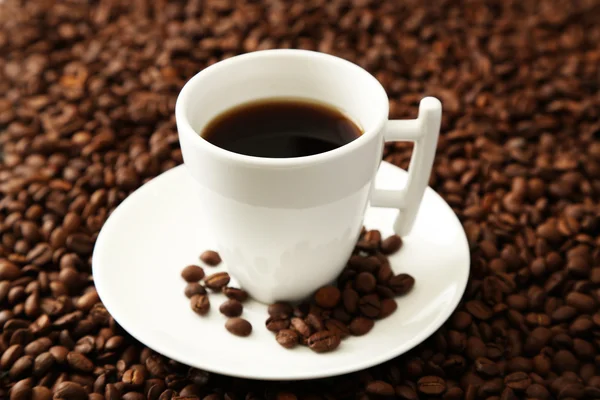 Kopje koffie op koffie bonen achtergrond — Stockfoto