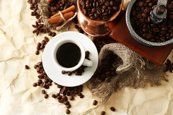 Cup of coffee, pot and grinder on beige background — Stock Photo, Image