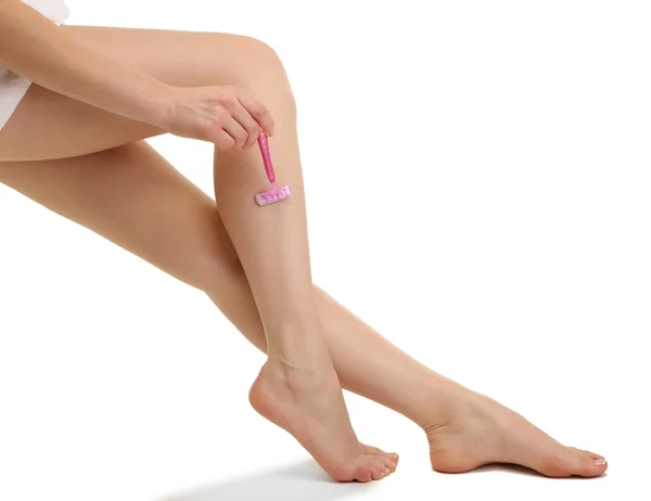 Bella donna si sta radendo la gamba, isolata su bianco — Foto Stock