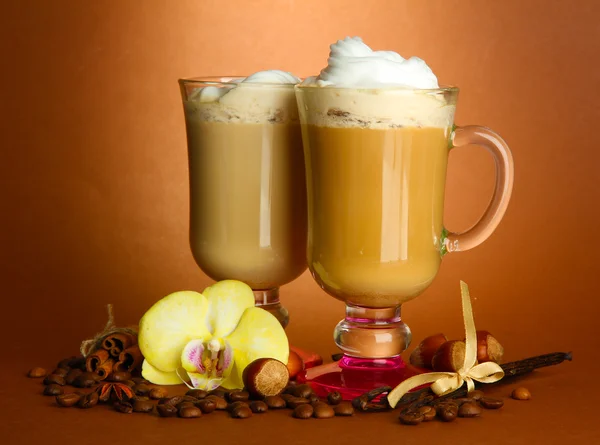 Fragrant coffee latte in glasses cups with spices, on brown background — Stock Photo, Image