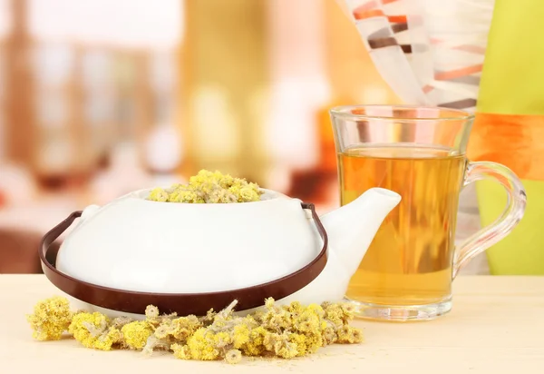 Ervas secas no bule de chá na mesa de madeira, no fundo brilhante. Foto conceitual de chá de ervas . — Fotografia de Stock