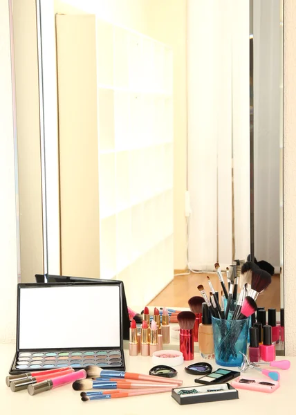 Cosmetici sul tavolo vicino specchietto — Foto Stock