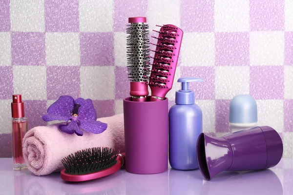 Brosses à cheveux, sèche-cheveux et bouteilles cosmétiques dans la salle de bain — Photo