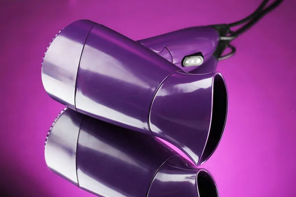 Hair dryer on purple background — Stock Photo, Image