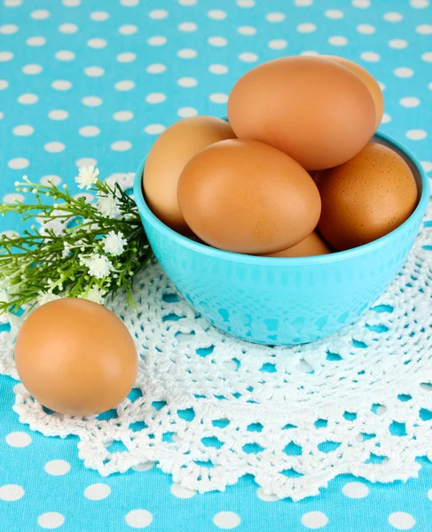 Eggs in bowl on blue tablecloth close-up — Stock Photo, Image