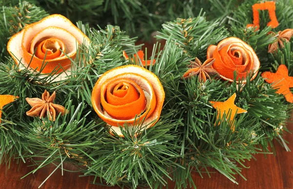 圣诞花环装饰着干桔皮木桌上的玫瑰 — 图库照片