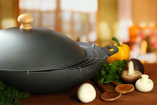 Svart wok pannan och grönsaker på trä köksbord, närbild — Stockfoto