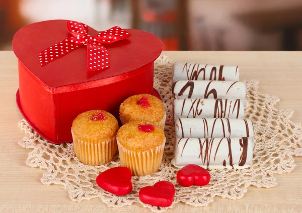 Słodkie ciasteczka z prezentem na stole w kawiarni — Zdjęcie stockowe