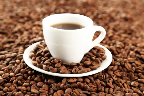 Cup of coffee on coffee beans background — Stock Photo, Image