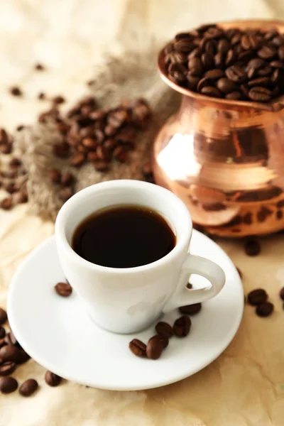 Cup and pot of coffee on beige background — Stock Photo, Image