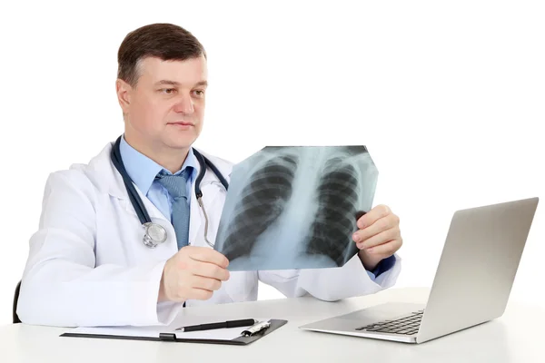 Medical doctor analysing x-ray image at desk isolated on white — Stock Photo, Image