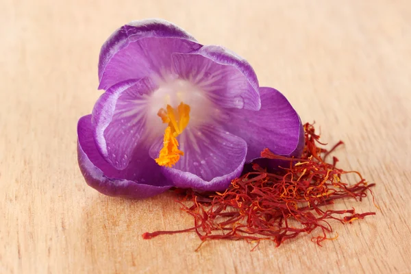 Beautiful purple crocus and saffron, on wooden background — Stock Photo, Image