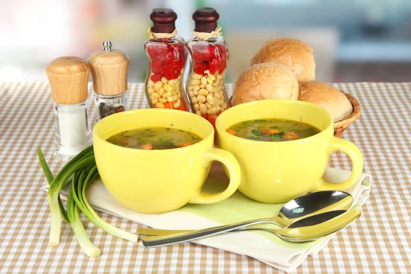 Fragrant soup in cups on table in kitchen