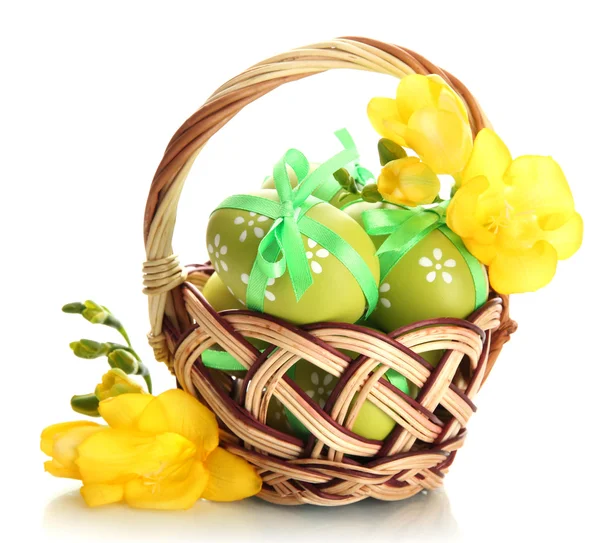 Ovos de páscoa brilhantes com arcos em cesta, isolados em branco — Fotografia de Stock