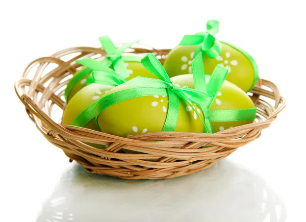 Яркие пасхальные яйца с луками в корзине, изолированные на белом — стоковое фото
