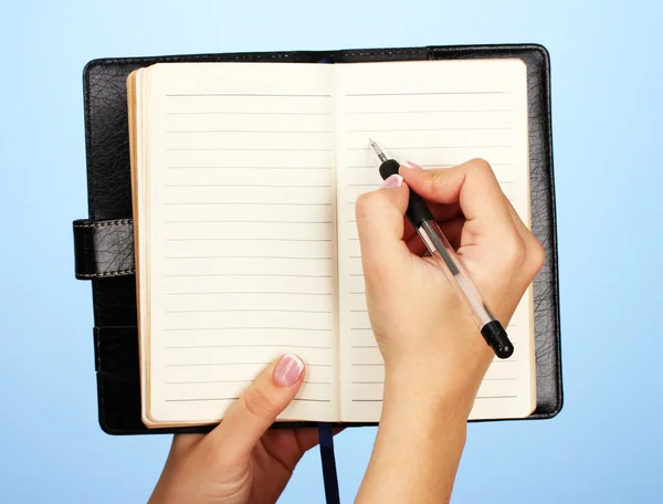 Hand schrijven op notebook, op een achtergrond met kleur Stockafbeelding