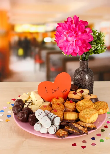 Sweet cookies with valentine card on plate on table in cafe Royalty Free Stock Images