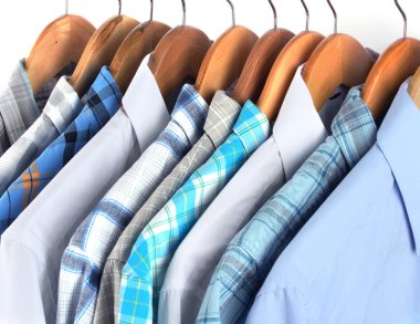 Shirts with ties on wooden hangers close-up clipart
