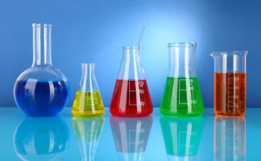 test tüpleri ile mavi arka plan üzerinde renkli sıvı