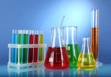 test tüpleri ile mavi arka plan üzerinde renkli sıvı