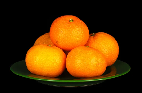 Tasty mandarines on color plate isolated on black — Stock Photo, Image