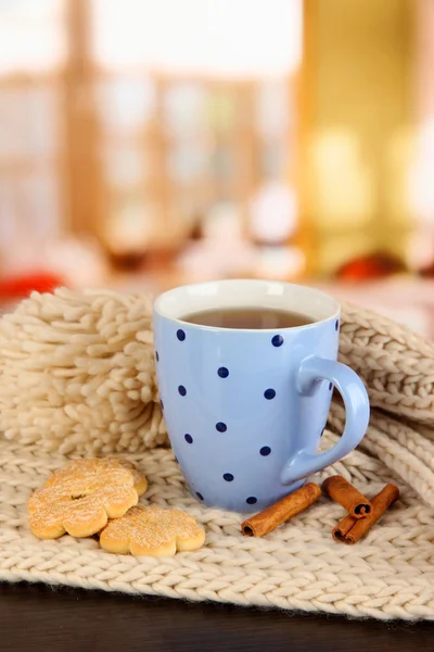 Taza de té con bufanda en la mesa en la habitación —  Fotos de Stock