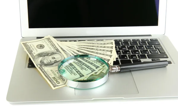 Money with magnifying glass on laptop isolated on white — Stock Photo, Image