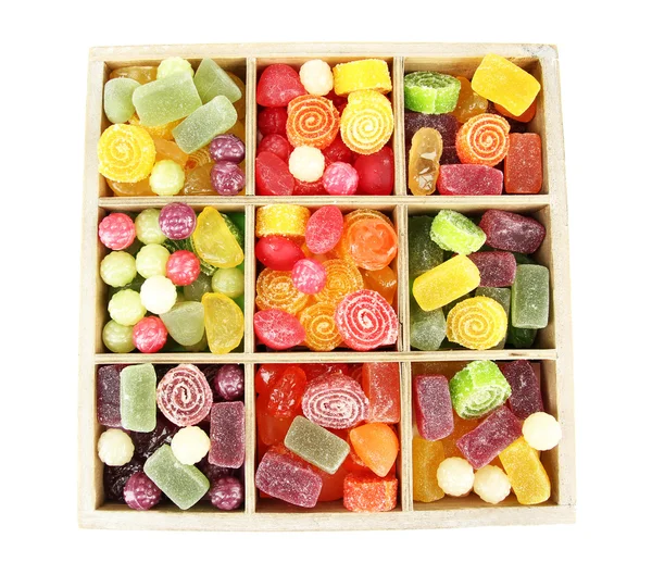 Mehrfarbige Bonbons in Holzkiste, isoliert auf weiß — Stockfoto
