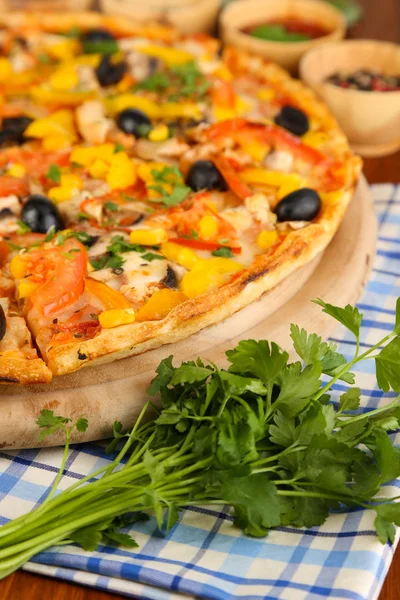 Tasty pizza with kitchen herbs on wooden table close-up — Stock Photo, Image