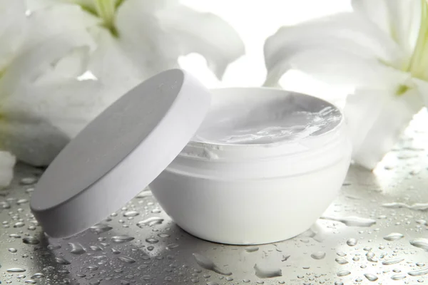 Cosmetische crème en mooie lily, close-up — Stockfoto