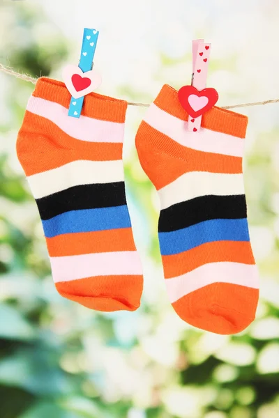 多彩的袜子挂在晾衣绳上，在明亮的背景上 — 图库照片
