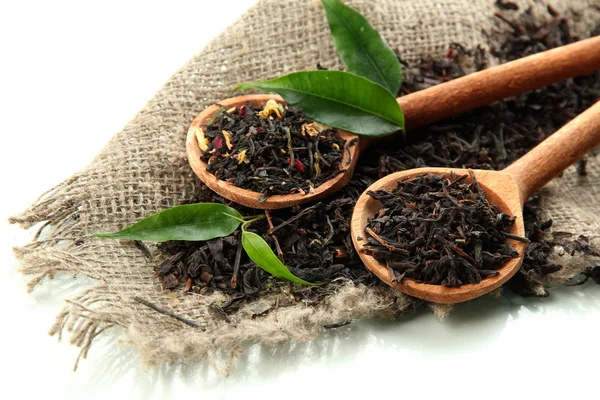 Dry tea with green leaves in wooden spoons, isolated on white — Stock Photo, Image