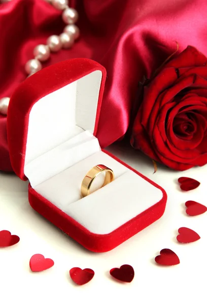 Красивая коробка с обручальным кольцом и розой на красном шелковом фоне Лицензионные Стоковые Фото