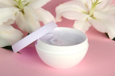 kozmetik krem ve pembe bir arka plan üzerinde güzel zambak