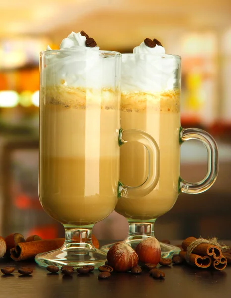 Geurende koffie latte in glazen bekers met kruiden, op tafel in café — Stockfoto