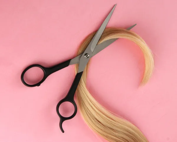 Cabelo e tesouras de corte, sobre fundo rosa — Fotografia de Stock