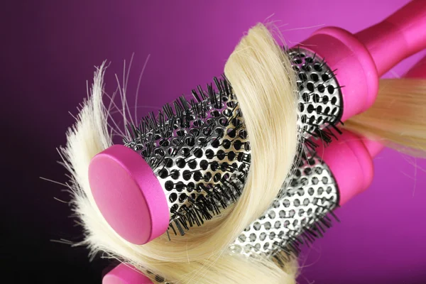 Escova de pente com cabelo no fundo roxo — Fotografia de Stock