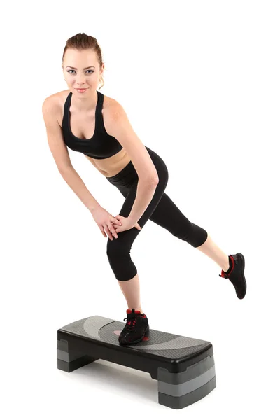 Mujer joven haciendo ejercicios de fitness en stepper aislado en blanco —  Fotos de Stock