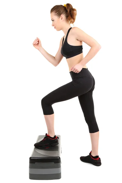 Mujer joven haciendo ejercicios de fitness en stepper aislado en blanco —  Fotos de Stock
