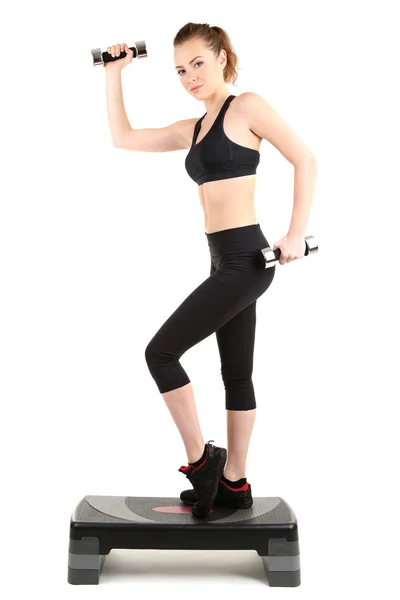 Genç bir kadın fitness egzersizleri üzerinde beyaz izole Step yapıyor — Stok fotoğraf