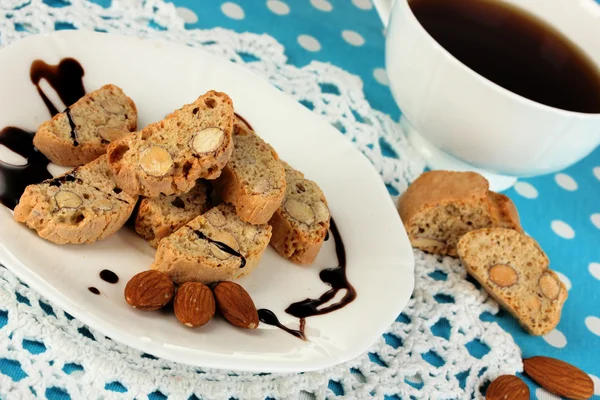 Biscoitos aromáticos cantuccini na placa com xícara de café na toalha de mesa azul close-up — Fotografia de Stock