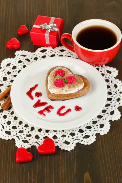 Biscotto al cioccolato in forma di cuore con tazza di caffè su tavolo di legno primo piano — Foto Stock