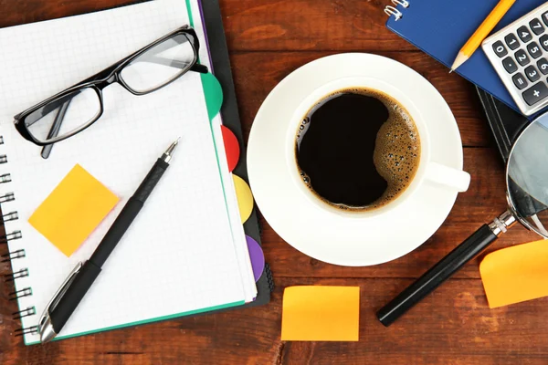 Kopp med kaffe på et bord dekket med dokumenter som lukkes – stockfoto