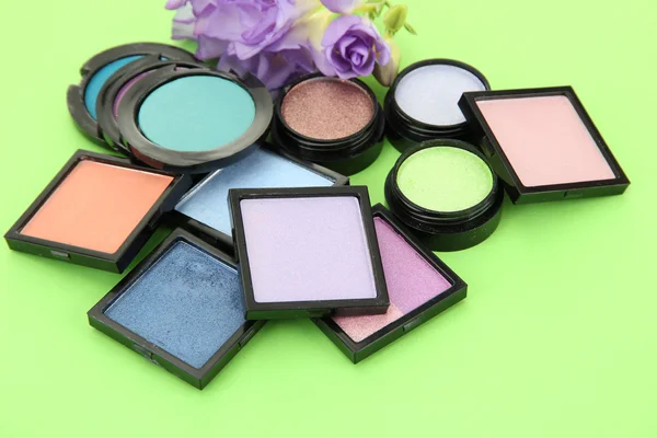 Beautiful bright eye shadows on green background — Stock Photo, Image