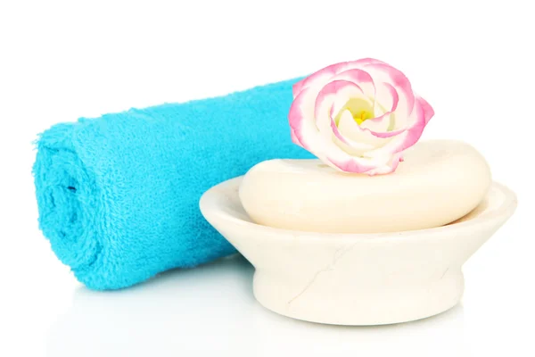 Walcowane niebieski ręcznik, mydła i piękny kwiat na białym tle — Zdjęcie stockowe