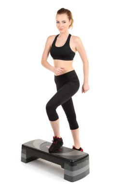 genç bir kadın fitness egzersizleri üzerinde beyaz izole Step yapıyor