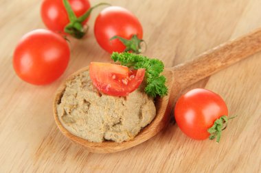 Tahta kaşıkta taze et, ahşap arka planda.