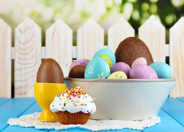Samenstelling van Pasen en chocolade-eieren op houten tafel op natuurlijke achtergrond — Stockfoto