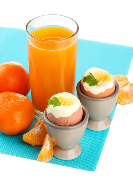 Leichtes Frühstück mit gekochten Eiern und einem Glas Saft, isoliert auf weiß — Stockfoto