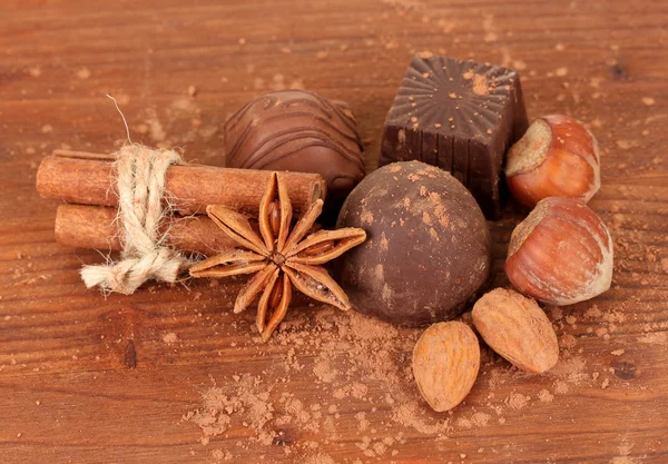 Dulces de chocolate con cacao, especias y nueces sobre fondo de madera — Foto de Stock